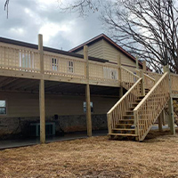 Very large raised deck with staircase and landing on back of Knoxville area home